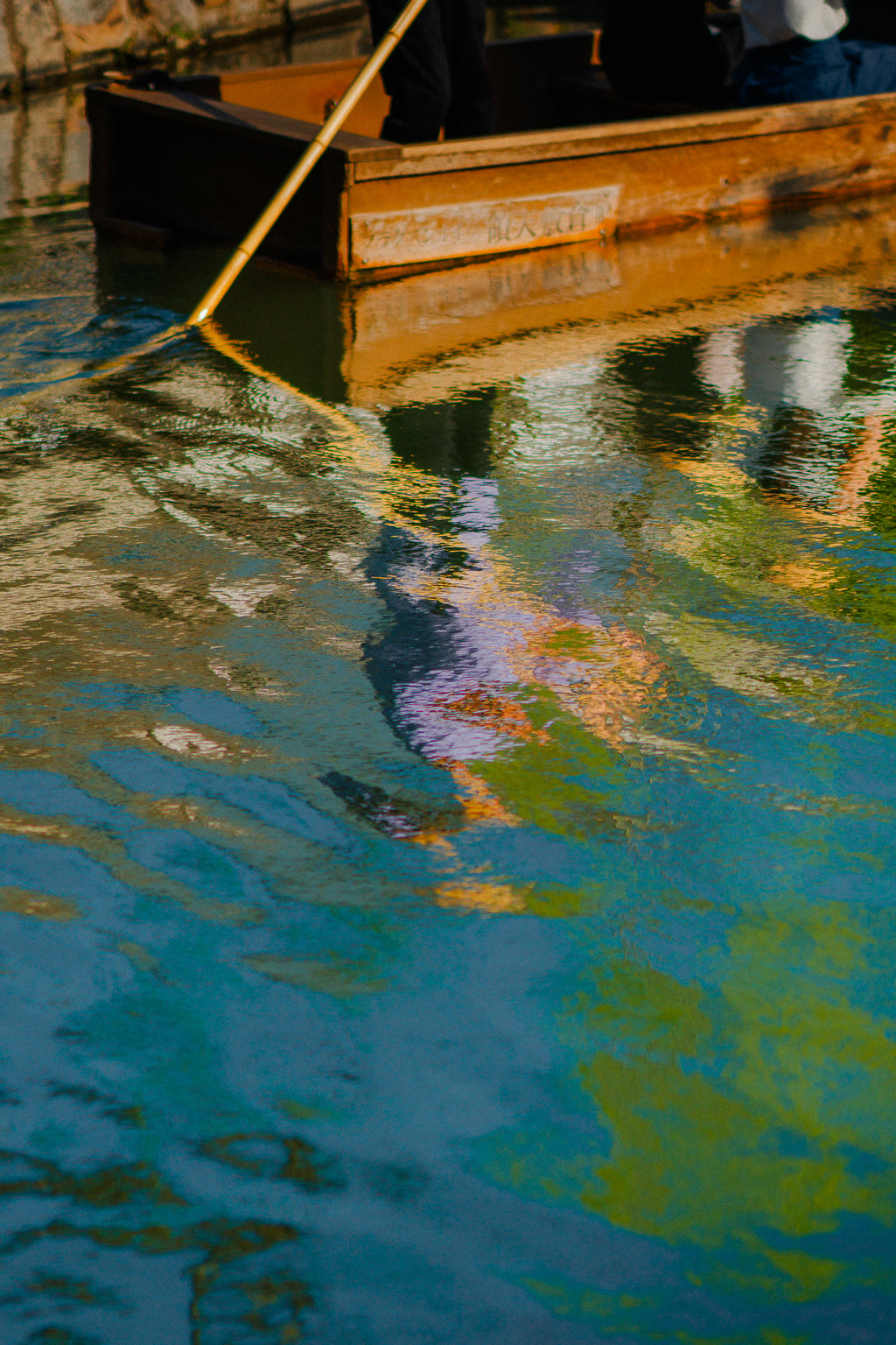Rust-colored metal object partially submerged in water with reflections - primary